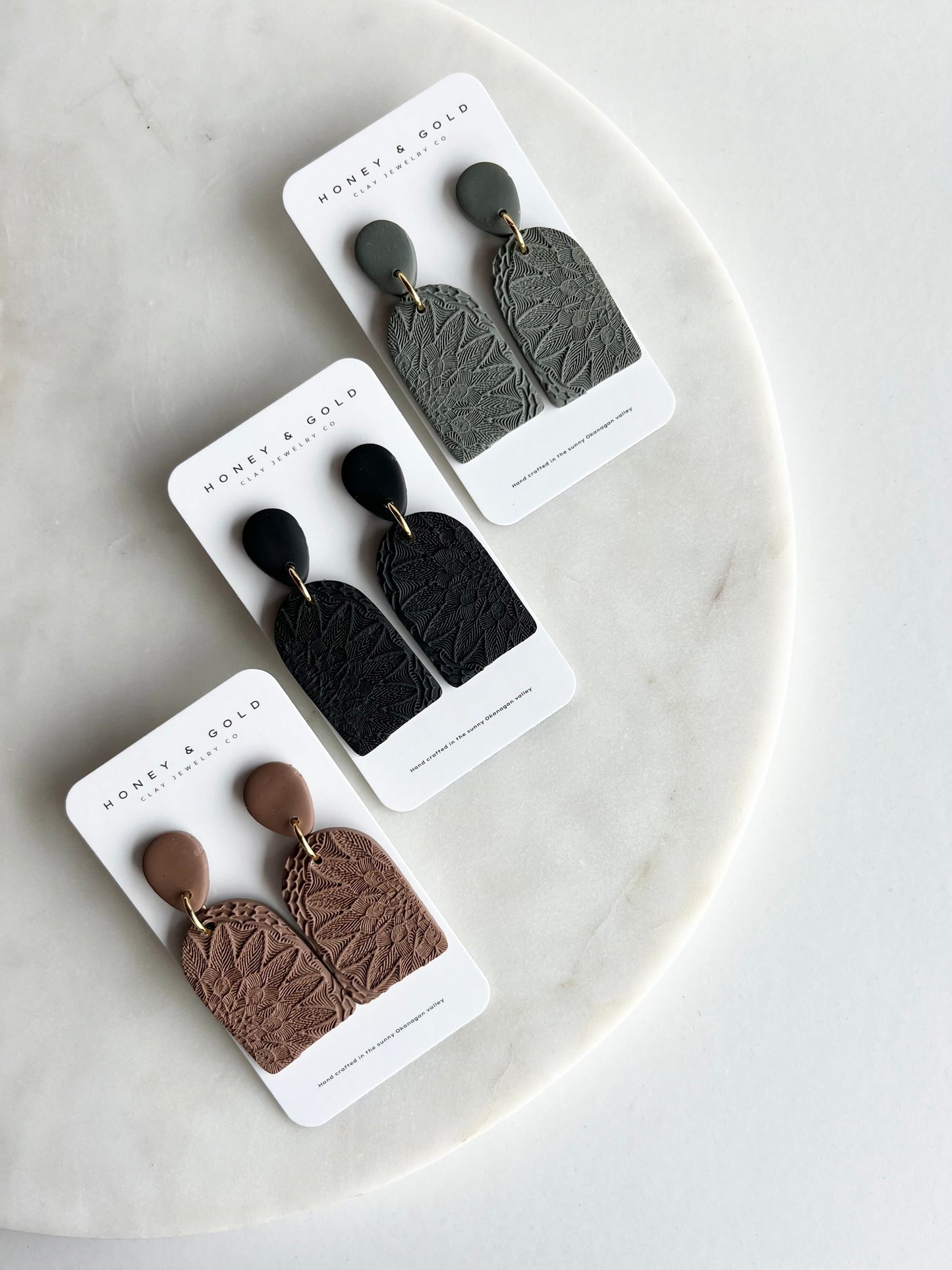 Drop-style earrings in a variety of velvety hues. Embellished in a mandala stamp with gold accents.