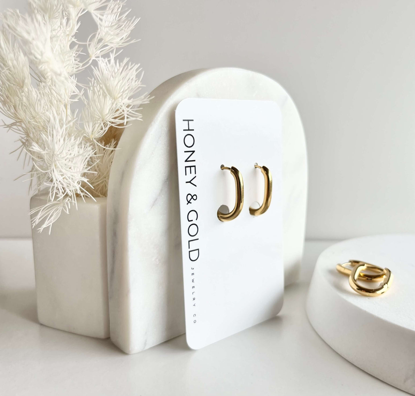 14K gold plated stainless steel chunky oval square hoops displayed on white card with marbled backdrop”