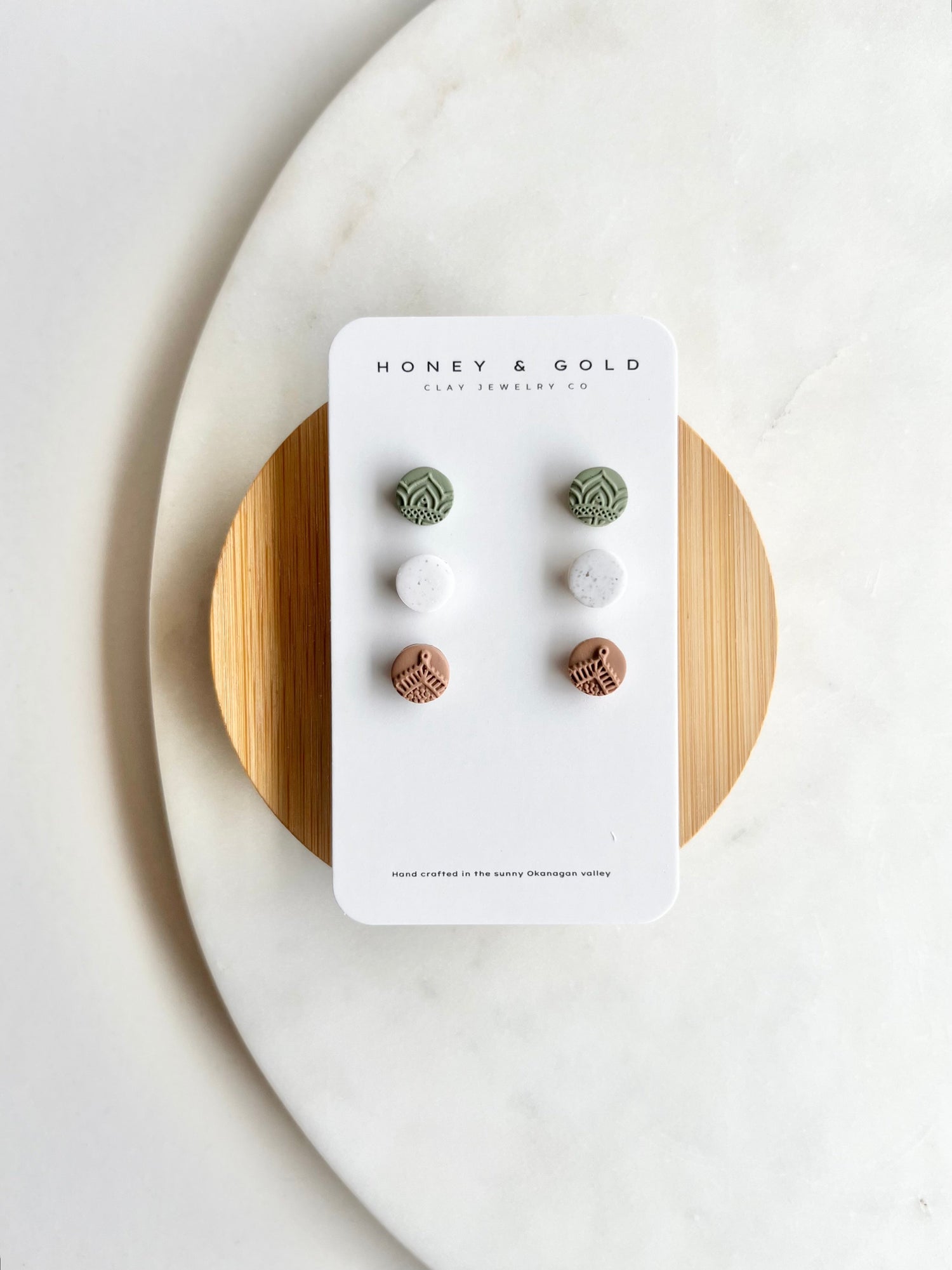 "Three pairs of stud style earrings in varying designs and colors, displayed against a neutral background. The earrings offer a versatile selection for different styling options."