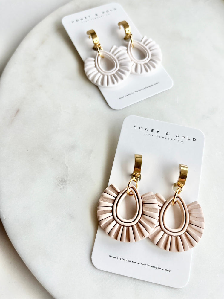 "Drop-style earrings in various designs and colors, displayed against a neutral background. The earrings feature unique drops, offering elegant and stylish options for any occasion."