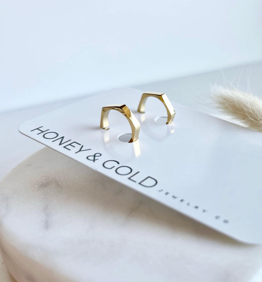 18k Gold Hexagon shaped earrings on a white marbled background