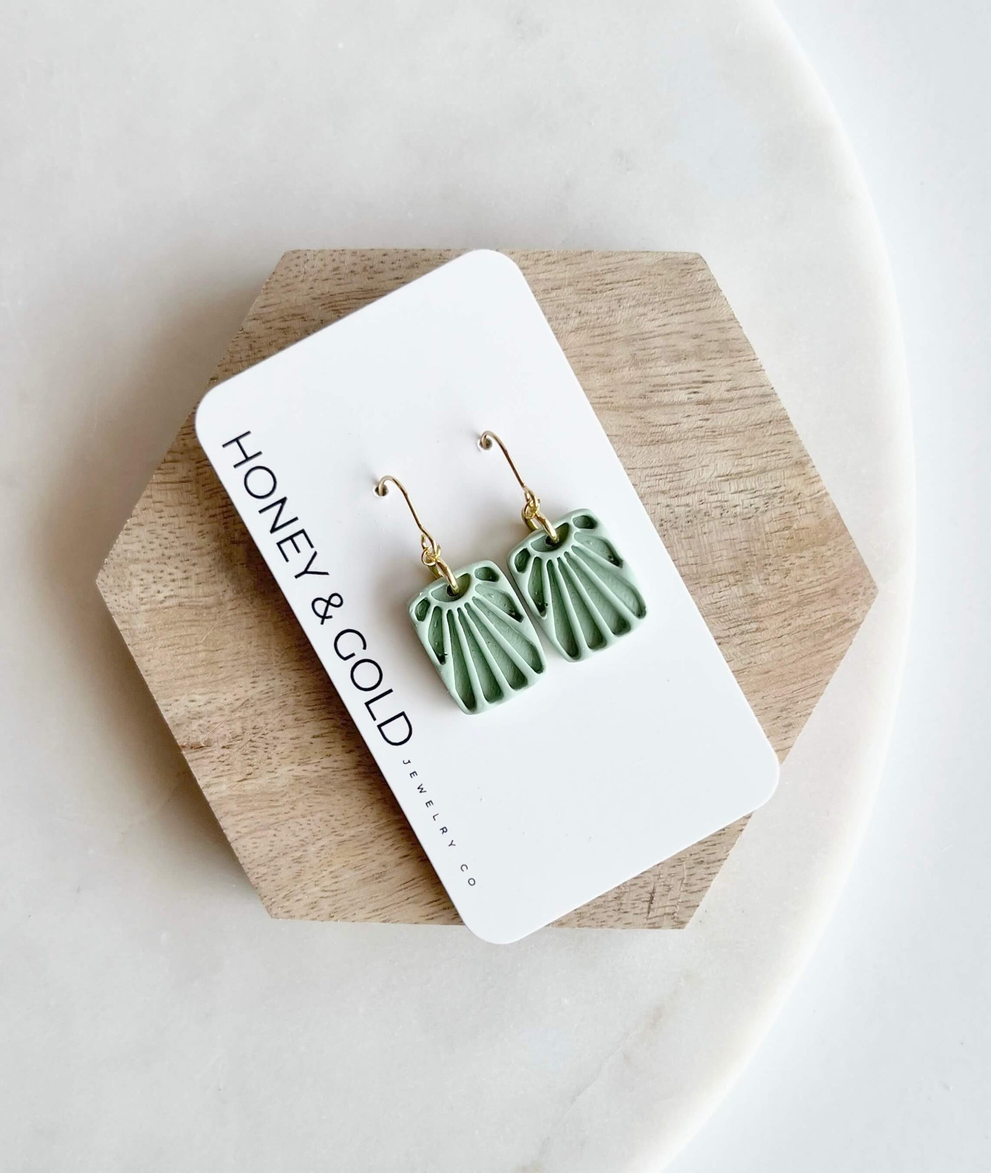 Sage "Sunset" earrings on a 'Honey & Gold' branded card.