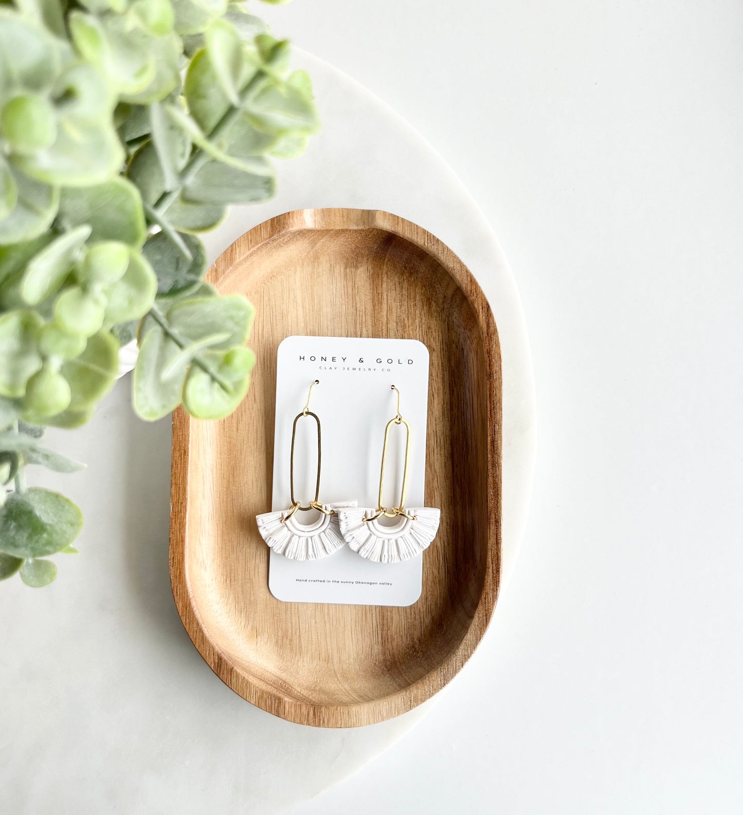 Indulge in the purity of timeless elegance with our white stainless steel drop-style earrings. Adorned with brass oval charms and delicately handcrafted faux macramé polymer clay embellishments, these earrings exude sophistication and grace. The pristine white hue adds a touch of refined beauty to any outfit, making them perfect for both casual chic and formal affairs. Elevate your ensemble with these exquisite earrings, a symbol of understated luxury and enduring style."