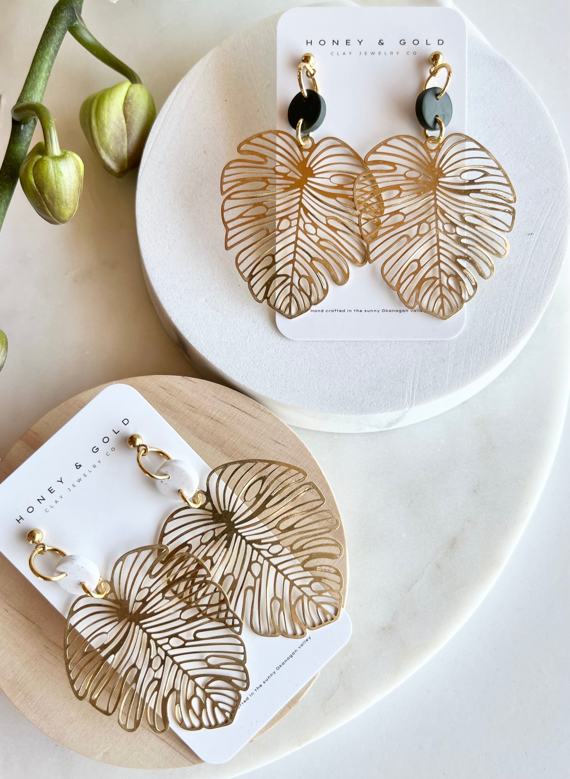 Monstera inspired earrings. Stainless Steel ball post topper with a brass Monstera motiff suspended below. Picture is captured on a white background.