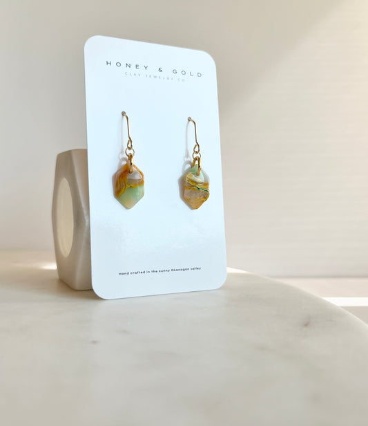 Elegant drop-style earrings featuring luminous Aurastone, radiating warmth and sophistication with fusions of rich yellow veining, teals, opaqueness, and intricate graining.